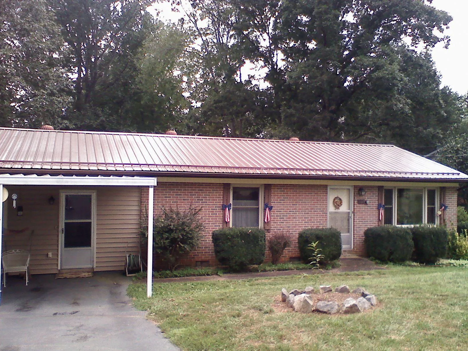 Bronze metal roof and carport on a brick ranch home — Roof Repair work by our crew in Hialeah